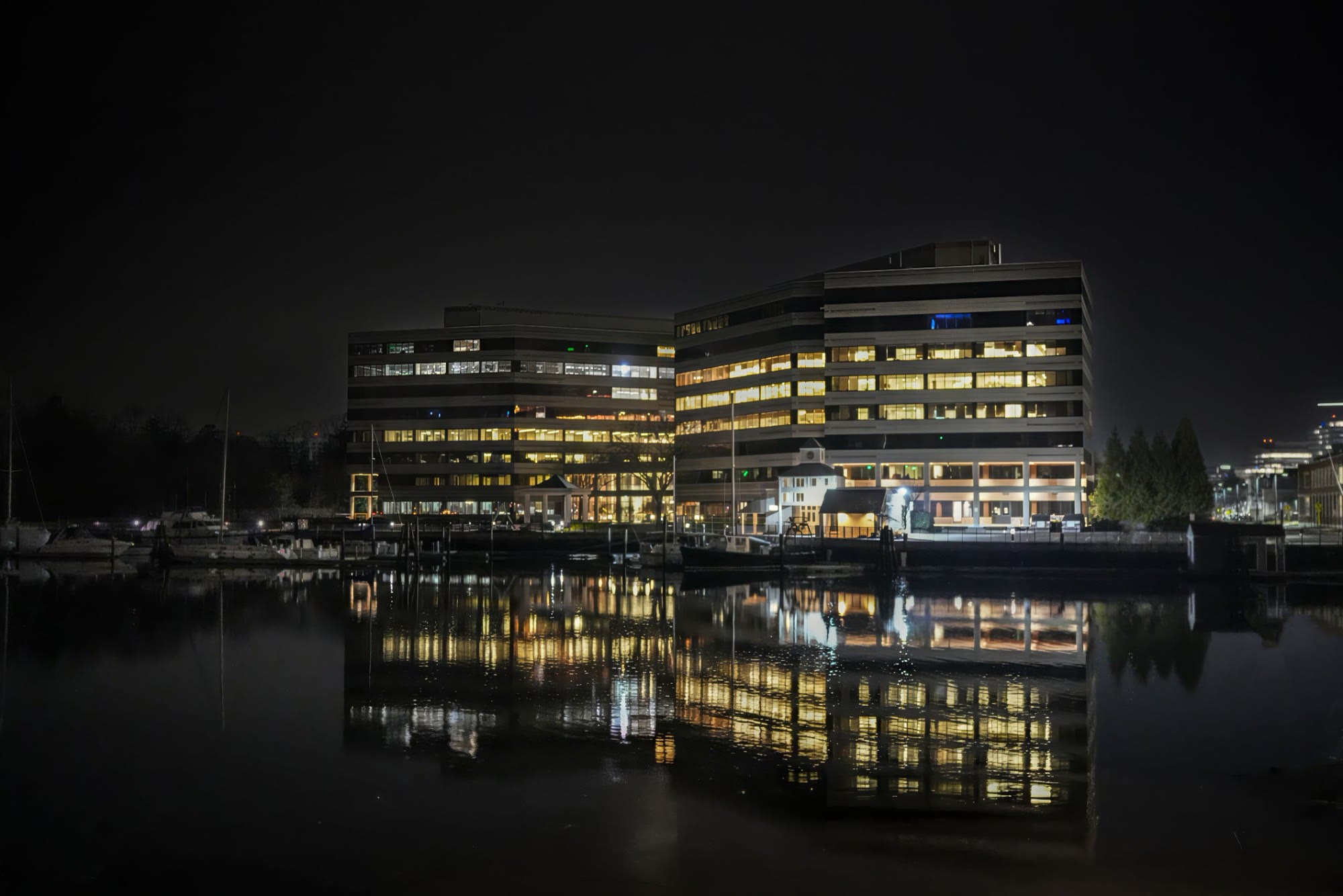 A waterfront residential development lit at night