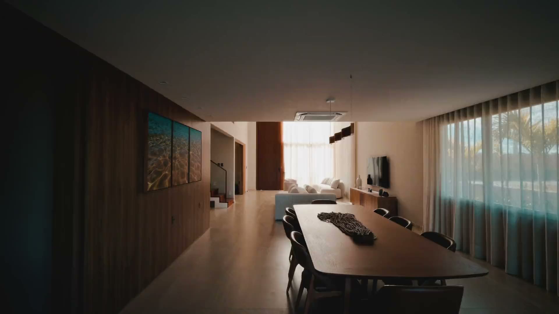 A long dining table in a quiet, low-lit room